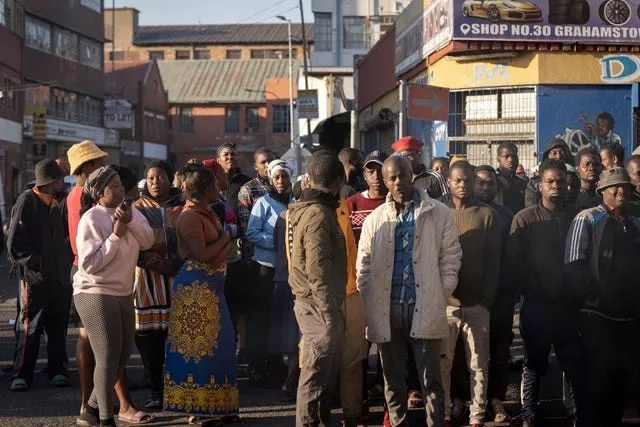 Local residents gather at the scene of a deadly blaze in Johannesburg