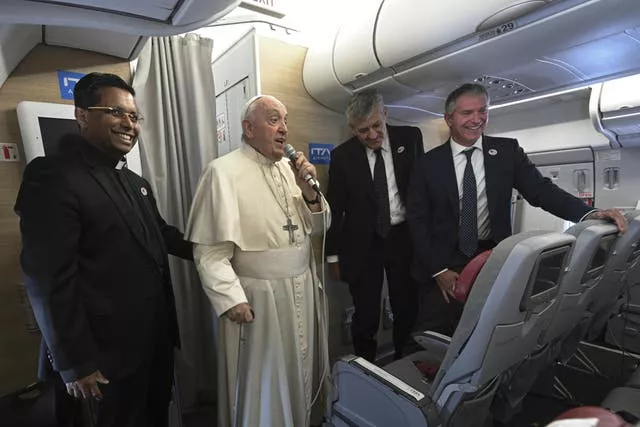 Pope Francis talks to reporters during the return flight from Mongolia