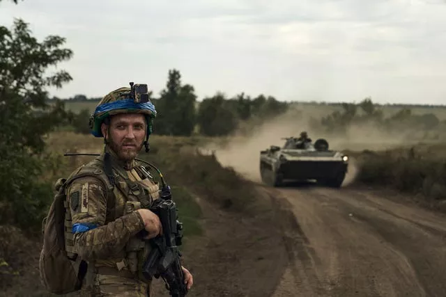 A soldier of Ukraine’s 3rd Separate Assault Brigade looks on against the background of an APC near Bakhmut on Monday