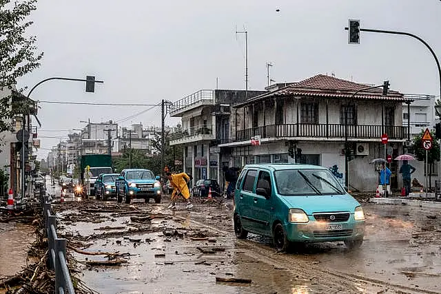 A man cleans debris from floodwater in the town of Volos, central Greece