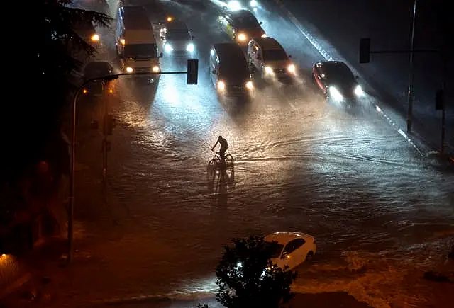 A cyclist rides through floodwater blocking the road due to heavy rain in Basaksehir district of Istanbul, Turkey, on Tuesday