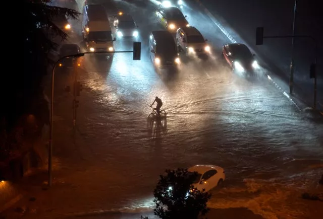 A cyclist rides through floodwater blocking the road due to heavy rain in Basaksehir district of Istanbul, Turkey, on Tuesday