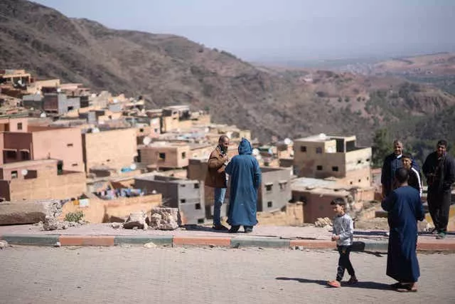 Des villageois se tiennent à côté des décombres après le tremblement de terre qui a frappé le village de Moulay Brahim, près de Marrakech, au Maroc. 