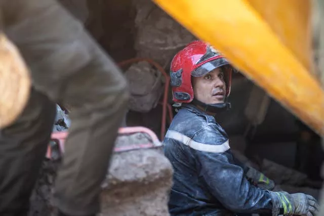 A rescue workers pauses while taking part in a rescue operation following the earthquake 