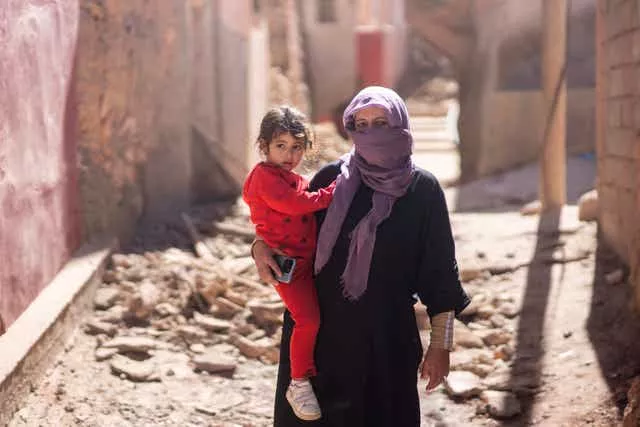 Uma mulher e sua filha estão do lado de fora de sua casa após o terremoto na aldeia de Moulay Ibrahim