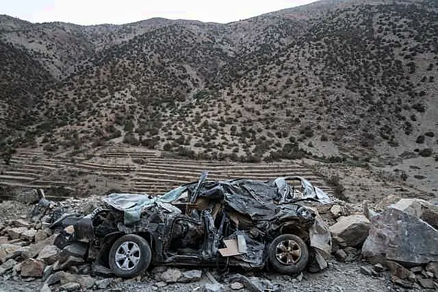 A car heavily damaged by the earthquake is left on the side of a road 