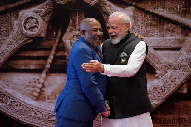 Indian Prime Minister Narendra Modi, right, shares a light moment with African Union chairman and president of the Union of the Comoros Azali Assoumani upon his arrival at Bharat Mandapam convention centre for the G20 summit in New Delhi, India