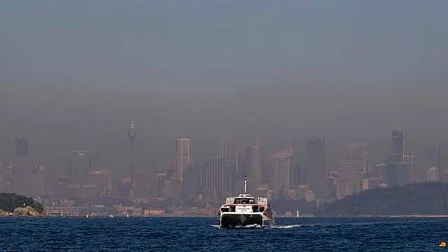 A ferry on the water as smoke covers Sydney