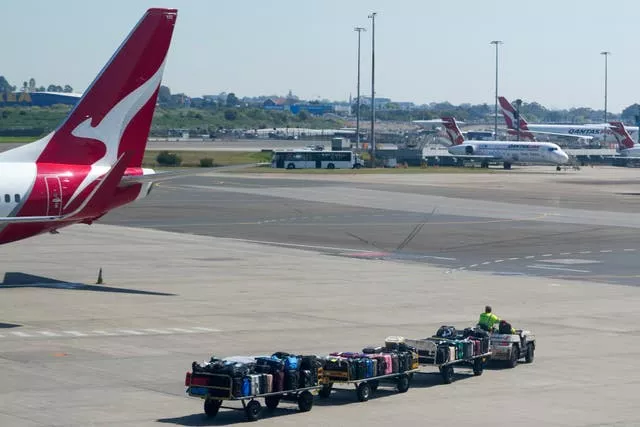 Baggage workers near a Qantas plane 