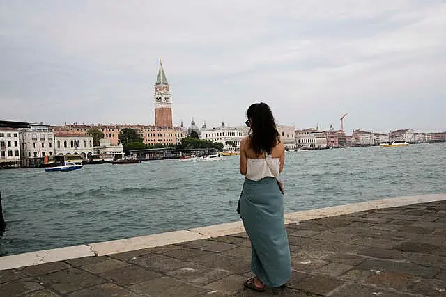 A tourist stands in front of St Mark’s Square in Venice, Italy