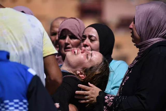 Mujeres lloran mientras lloran a las víctimas del terremoto 