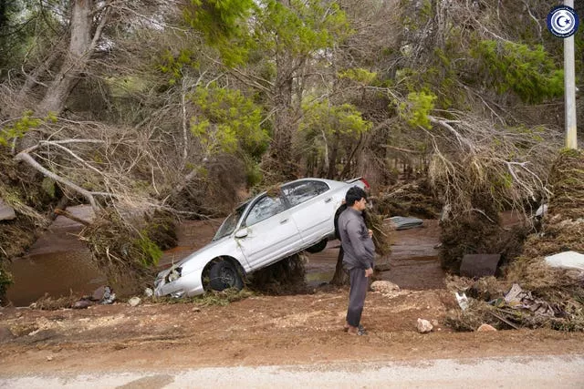 A car sits partly suspended in trees after being carried by floodwaters in Derna, Libya
