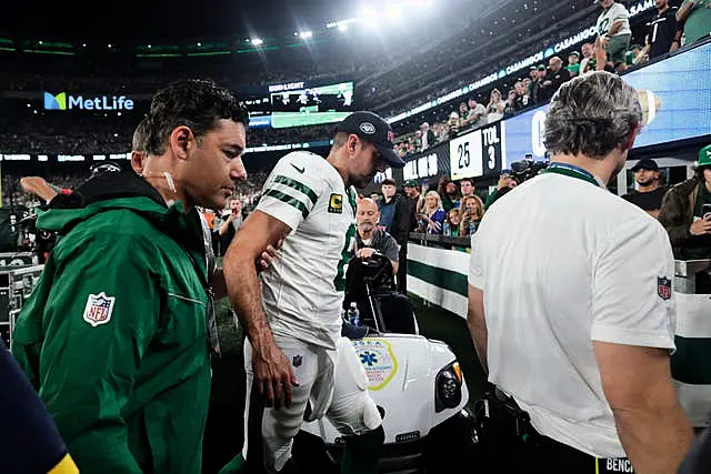 New York Jets quarterback Aaron Rodgers is helped off the field after getting injured during the first quarter of an NFL football game against the Buffalo Bills in East Rutherford, New Jersey