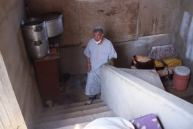 Derna flood survivor Abdul Salam Anwisi walks up the stairs at his damaged home