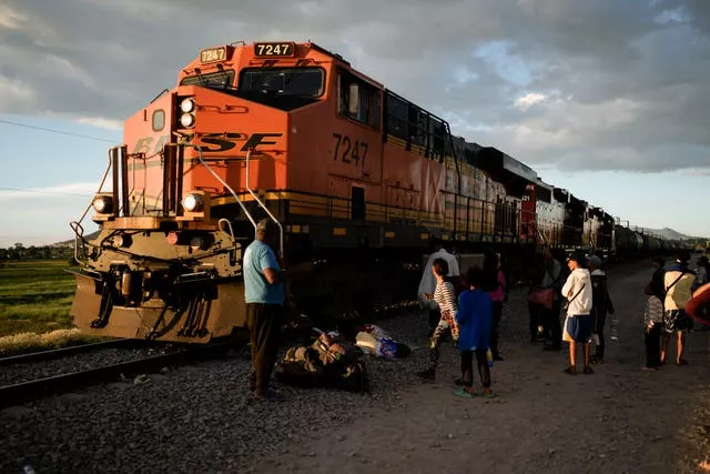 Migrants watch a train go past in Mexico