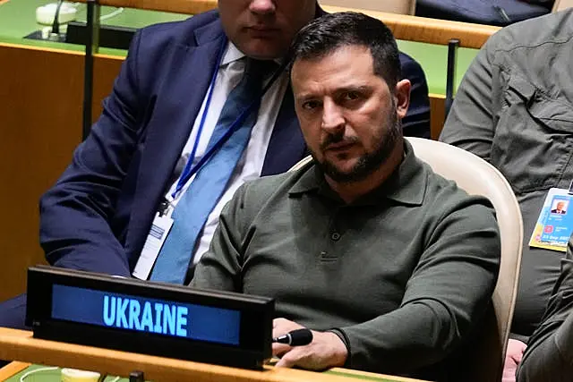 Ukrainian President Volodymyr Zelensky listens to speakers