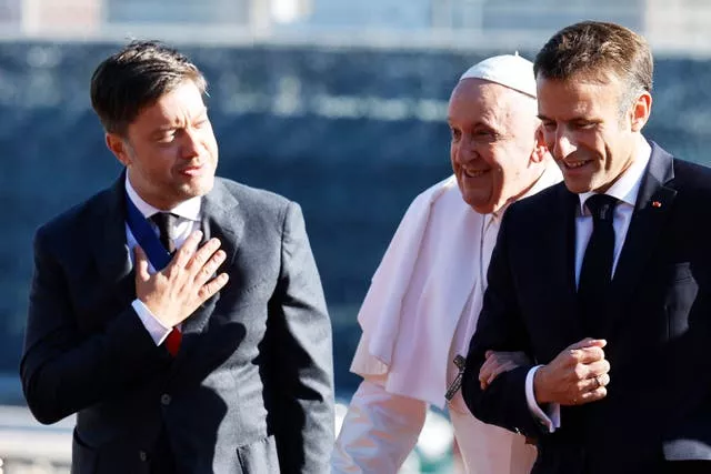 French president Emmanuel Macron, right, and mayor of Marseille Benoit Payan welcome Pope Francis before the final session of the Rencontres Mediterraneennes meeting at the Palais du Pharo in Marseille, southern France 