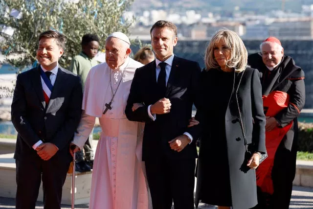 French President Emmanuel Macron, his wife Brigitte Macron and mayor of Marseille Benoit Payan, left, welcome Pope Francis at the final session of the Rencontres Mediterraneennes meeting at the Palais du Pharo in Marseille, southern France