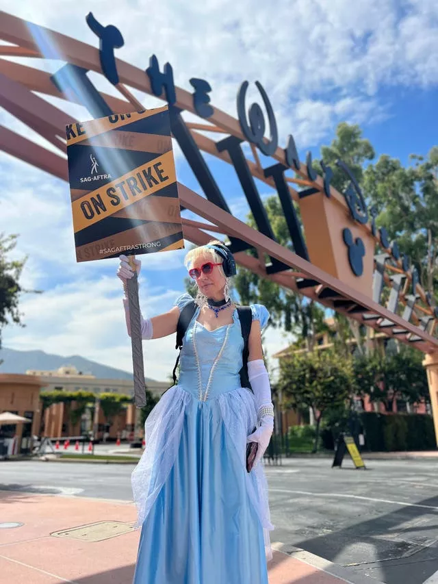 Andrea Calabrese, dressed as Cinderella, carries a sign on the picket line outside Walt Disney Studios