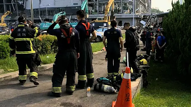 Firefighters take rest near the burned factory