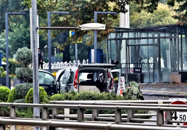 Um especialista em eliminação de bombas trabalha ao lado de um carro após uma explosão em Ancara 