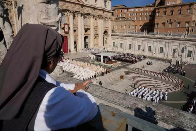 Uma freira observa um terraço enquanto o Papa Francisco preside a missa 