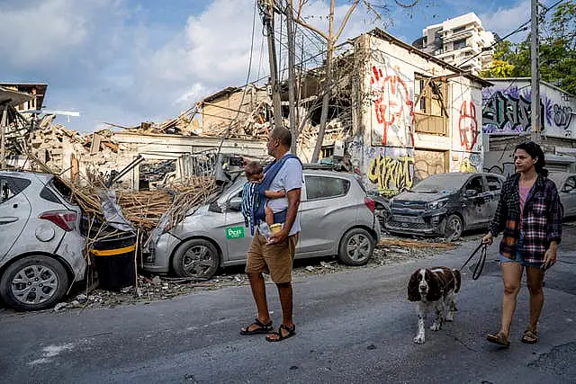 Israelis inspect the rubble of a building a day after it was hit by a rocket fired from the Gaza Strip