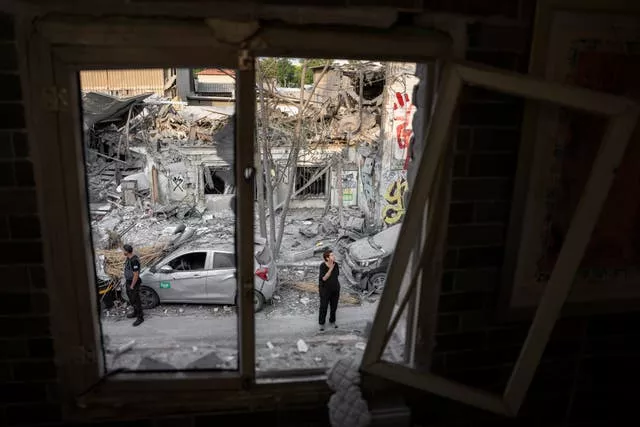 Israelenses inspecionam os escombros de um edifício