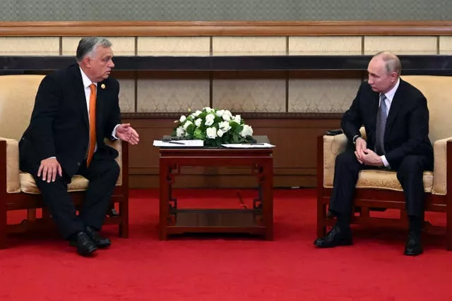 Vladimir Putin listens to Viktor Orban during their talks in Beijing
