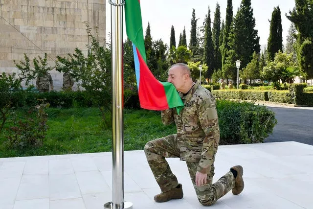 Ilham Aliyev kneeling to kiss national flag