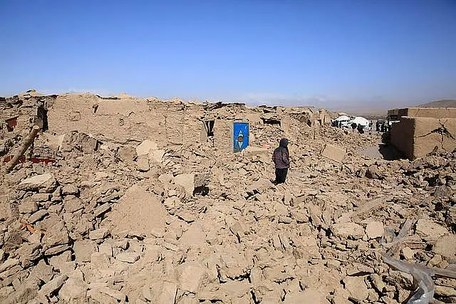 An Afghan boy stands amid the debris following the earthquake in Herat province 