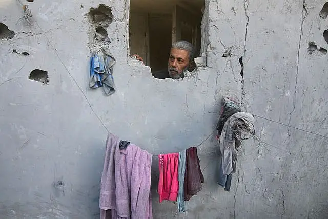 A Palestinian looks on from his house, damaged by Israeli airstrikes, in Rafah, southern Gaza Strip