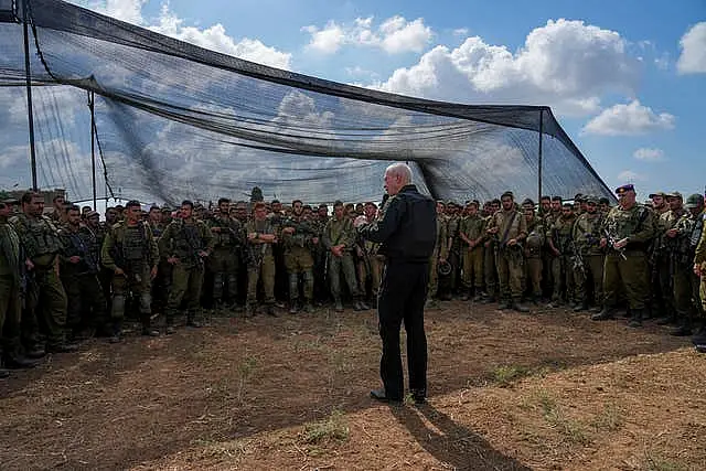 Israel’s defence minister Yoav Gallant, wearing a protective vest, speaks with Israeli soldiers in a staging area near the border with the Gaza Strip in southern Israel