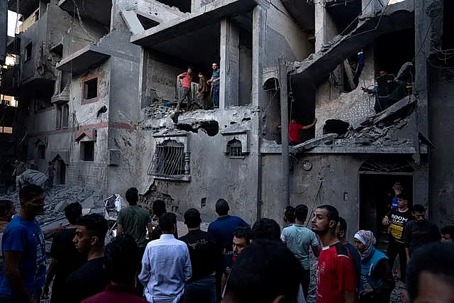 Palestinians evacuate wounded from a building destroyed in Israeli bombardment in Khan Younis, Gaza Strip