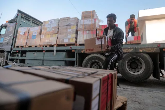Palestinians unload boxes of medicine from a truck