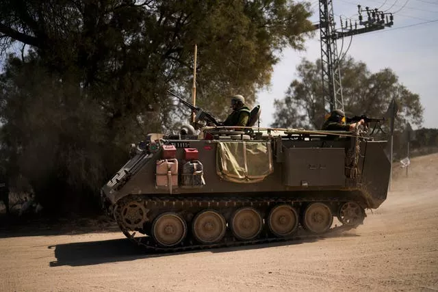 Soldiers drive a military vehicle near the border between Israel and the Gaza Strip
