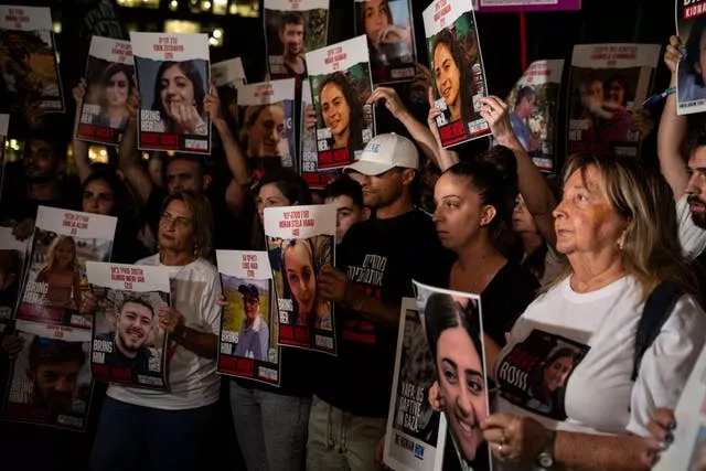 Relatives of people kidnapped by Hamas militants hold pictures of their loved ones during a protest in Tel Aviv