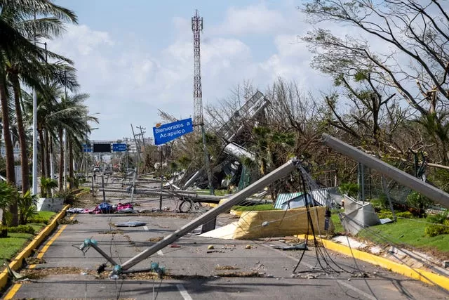 Downed electrical poles and lines blown over by Hurricane Otis blanket a road in Acapulco, Mexico