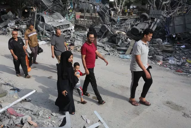 Palestinians pass by the destruction after the Israeli bombardment of the Gaza Strip in Rafah