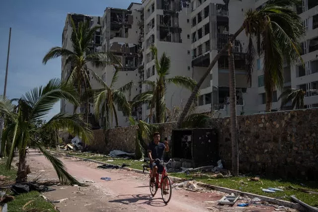 A man rides past damage in Acapulco