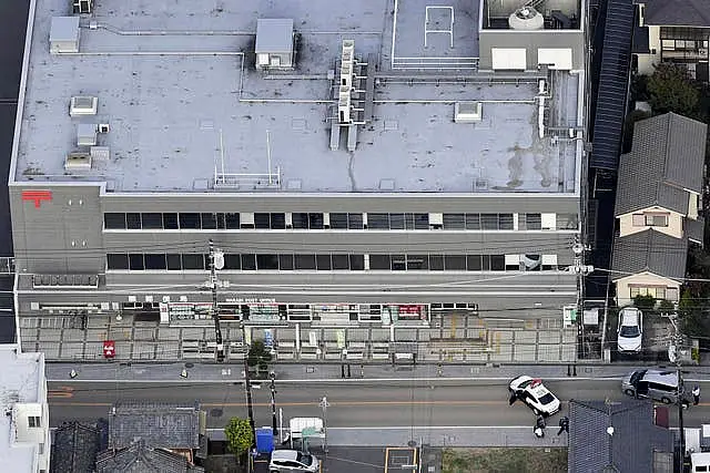 First responders take position outside the post office in Warabi city, Saitama prefecture, north of Tokyo 