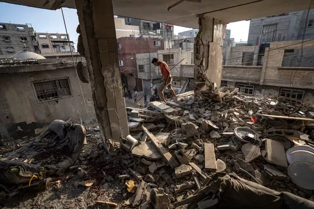 Palestinians look at the destruction after Israeli strikes on the Gaza Strip in Khan Younis