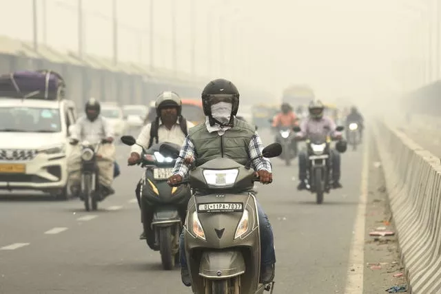 Motociclistas usam máscaras em Nova Delhi