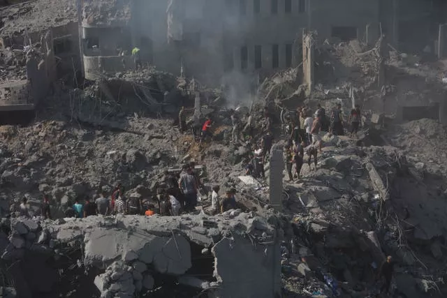 Palestinians look for survivors in the rubble of a destroyed building following an Israeli air strike in the Gaza Strip
