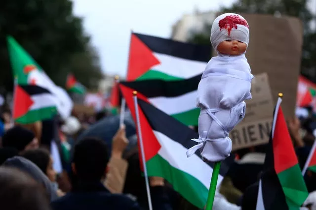 A mock dead baby is carried during a demonstration to support the Palestinian people in Gaza in Paris on Saturday