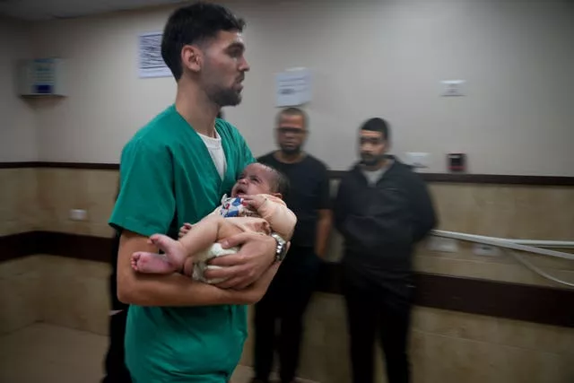 Um bebê palestino ferido no bombardeio israelense na Faixa de Gaza é levado a um hospital em Deir al-Balah