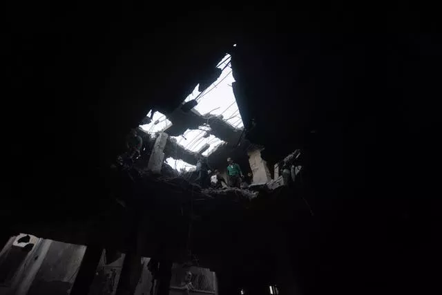 Palestinos procuram sobreviventes dentro dos restos de um prédio destruído