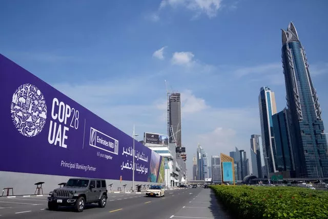 Cars pass a billboard advertising Cop28 in Dubai, United Arab Emirates