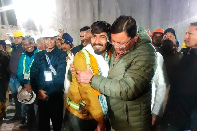 Pushkar Singh Dhami, right, chief minister of the state of Uttarakhand, greets a worker rescued from the site of an under-construction road tunnel that collapsed in Silkyara in the northern Indian state of Uttarakhand, India