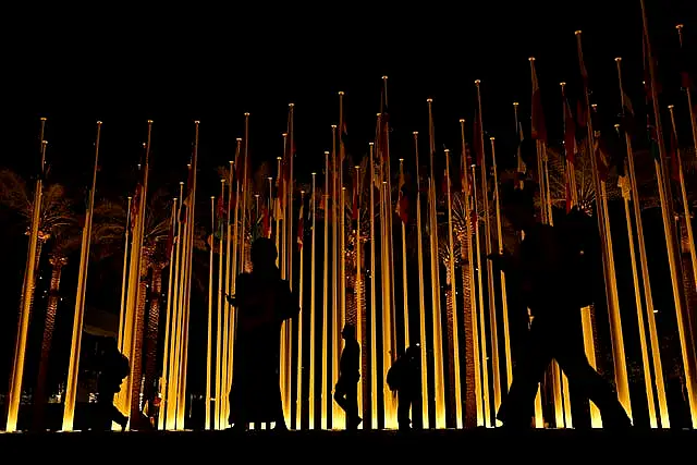 People walk near flags during the the Cop28 summit in Dubai